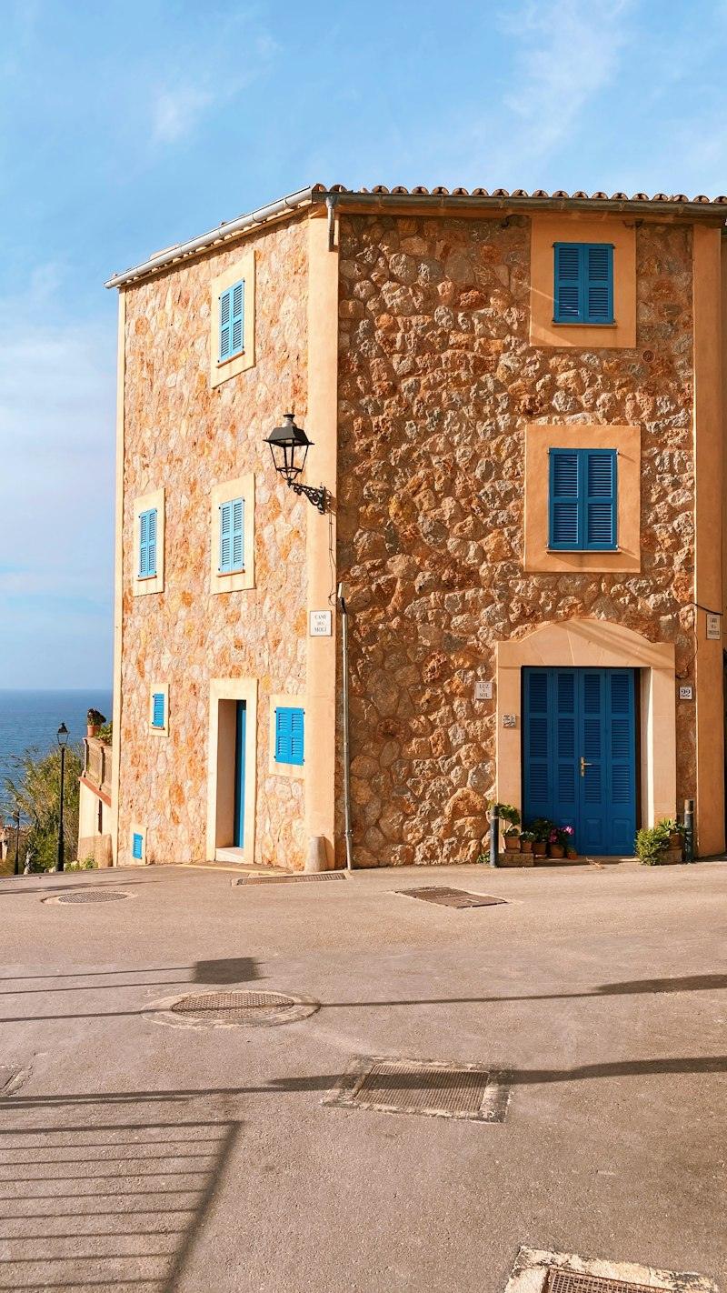 Casa de pedra amb porta i finestres blaves