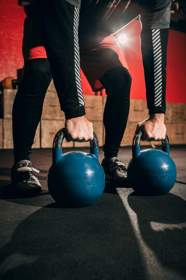 Mans agafant dues kettlebells blaves