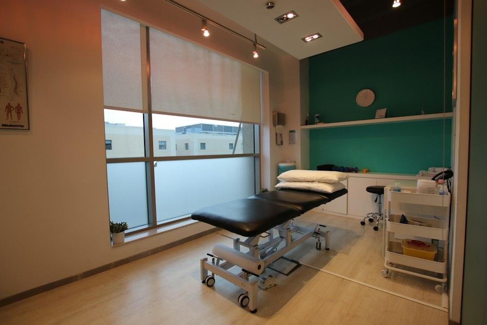 Sala de tractament lluminosa amb llitera i finestrals