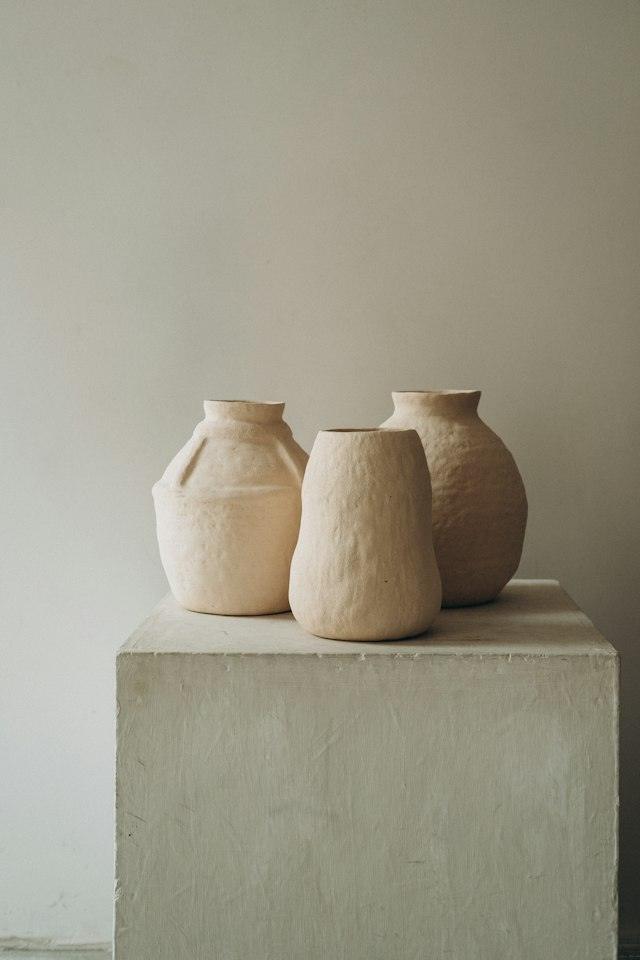 Tres gerros de terracota sobre un pedestal blanc