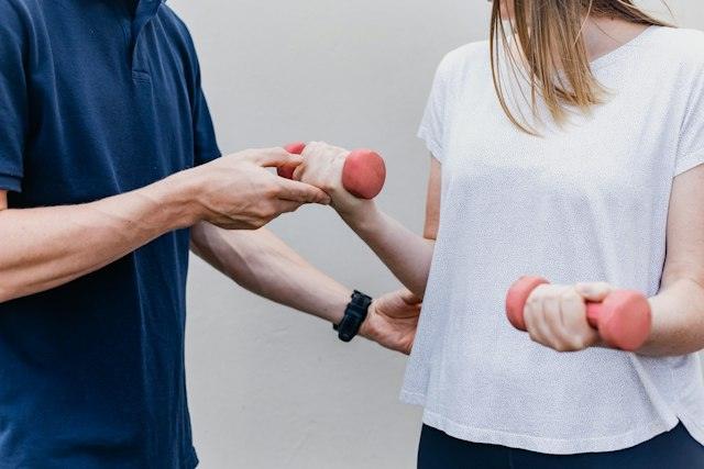 Professional guiant un exercici amb peses lleugeres