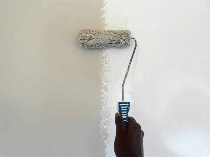 Persona pintant una paret amb un corró