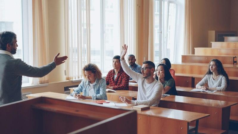 Alumnes aixecant la mà durant una classe