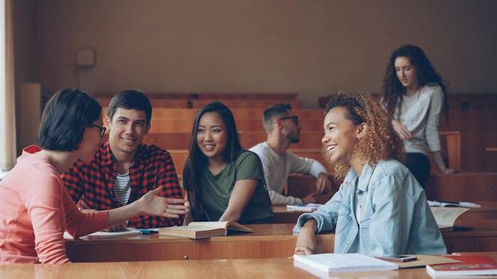 Estudiants rient i parlant en una aula