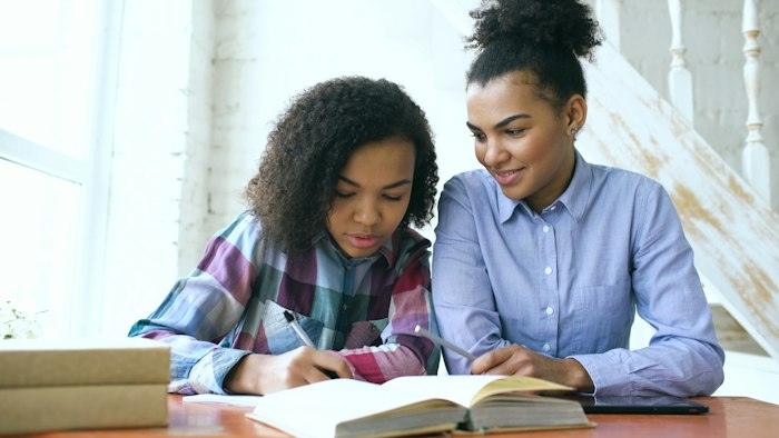 Professora ajudant una alumna amb els deures