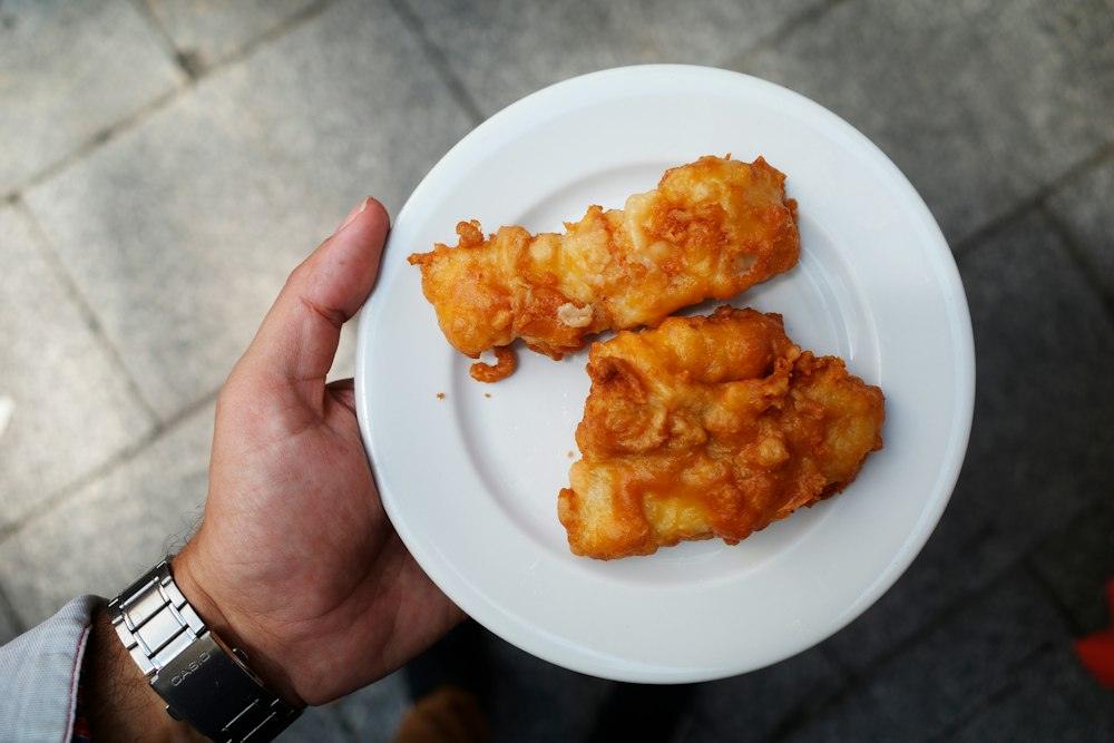 Plat amb dos fregits daurats a la mà del cambrer